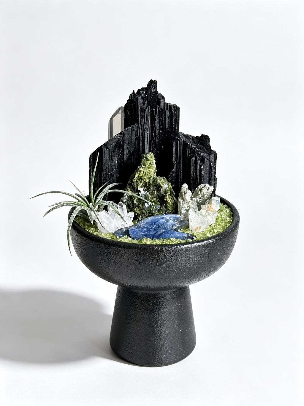 one-of-one crystal garden with black tourmaline, green phantom quartz, blue kyanite, silver air plant; front view on pure white background.
