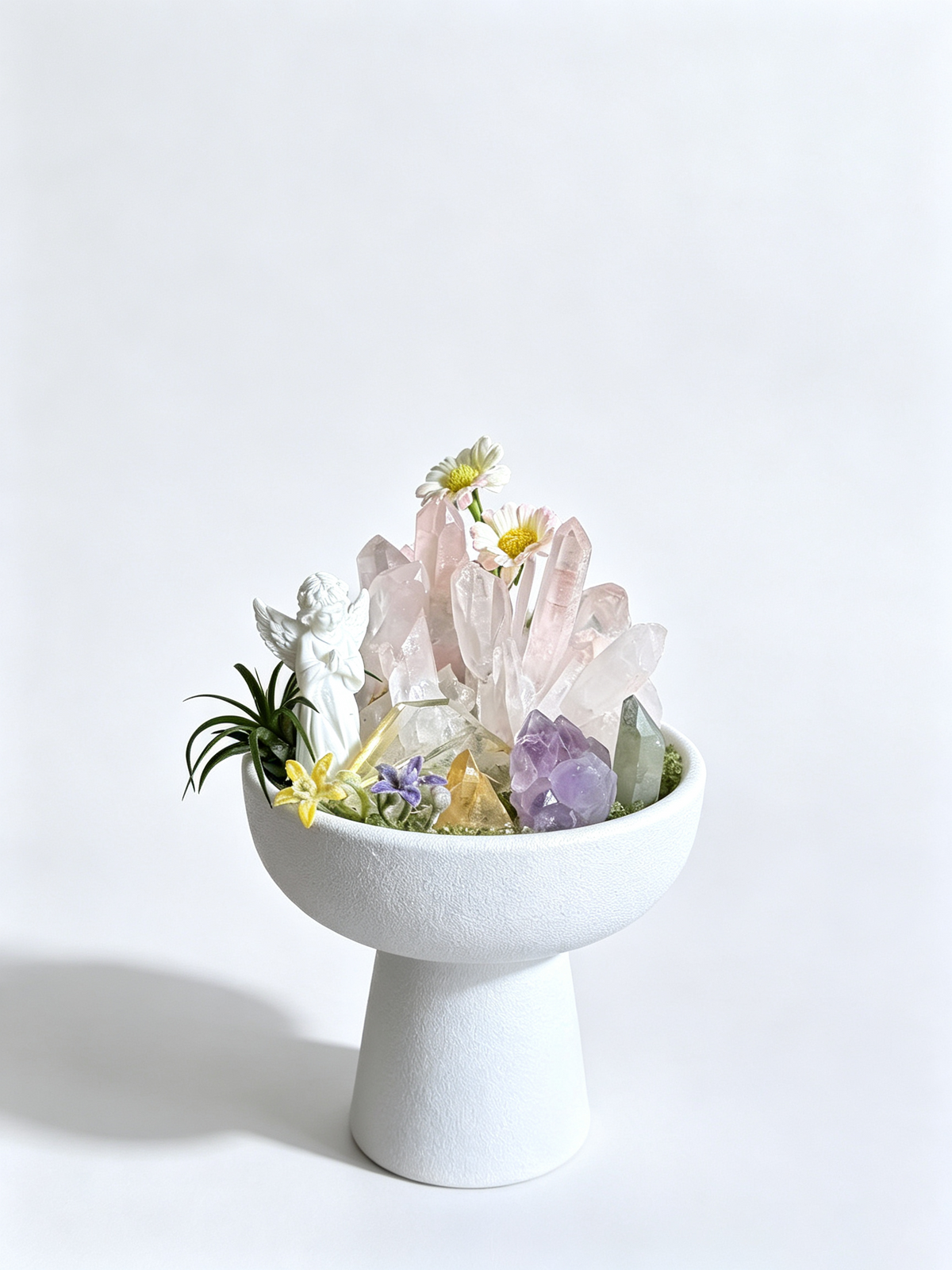 one-of-one crystal garden with porcelain angel, celestite geode, blue calcite, clear quartz, air plant; front view on pure white background.
